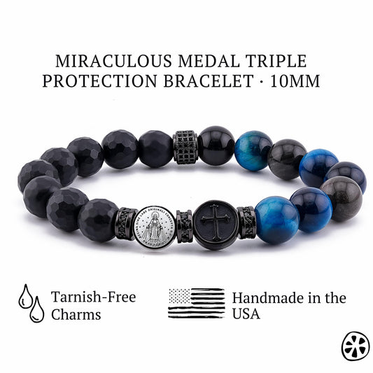 Product image of a Miraculous Medal triple protection bracelet featuring 10mm faceted black onyx beads, deep blue tiger eye gemstones, and a tarnish-free stainless steel Miraculous Medal charm paired with a black cross accent. The bracelet includes black CZ-accented spacers and glossy gemstone finishes. Displayed on a clean white background with icons for tarnish-free charms and handmade craftsmanship in the USA.