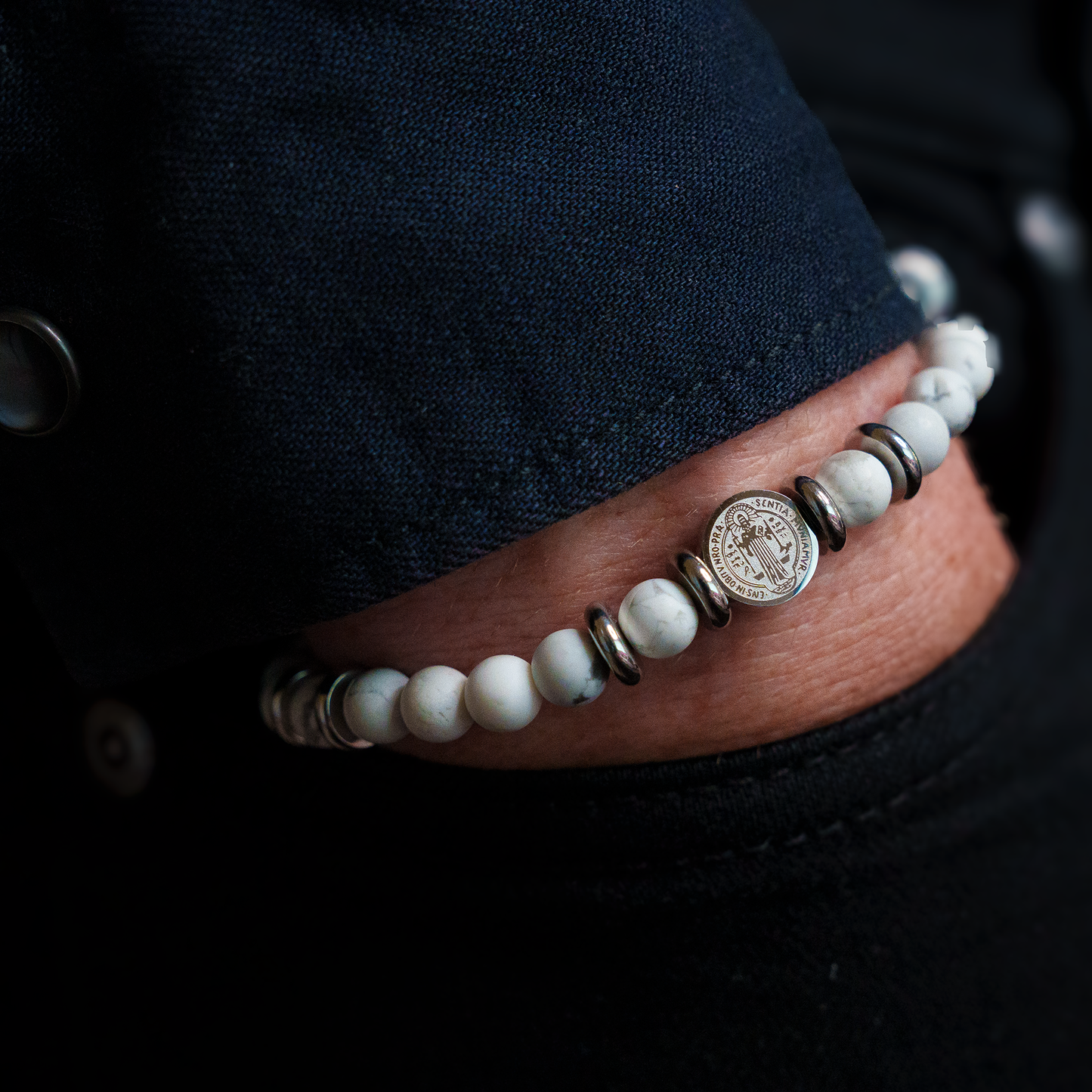 man wearing rosary bracelet white st benedict