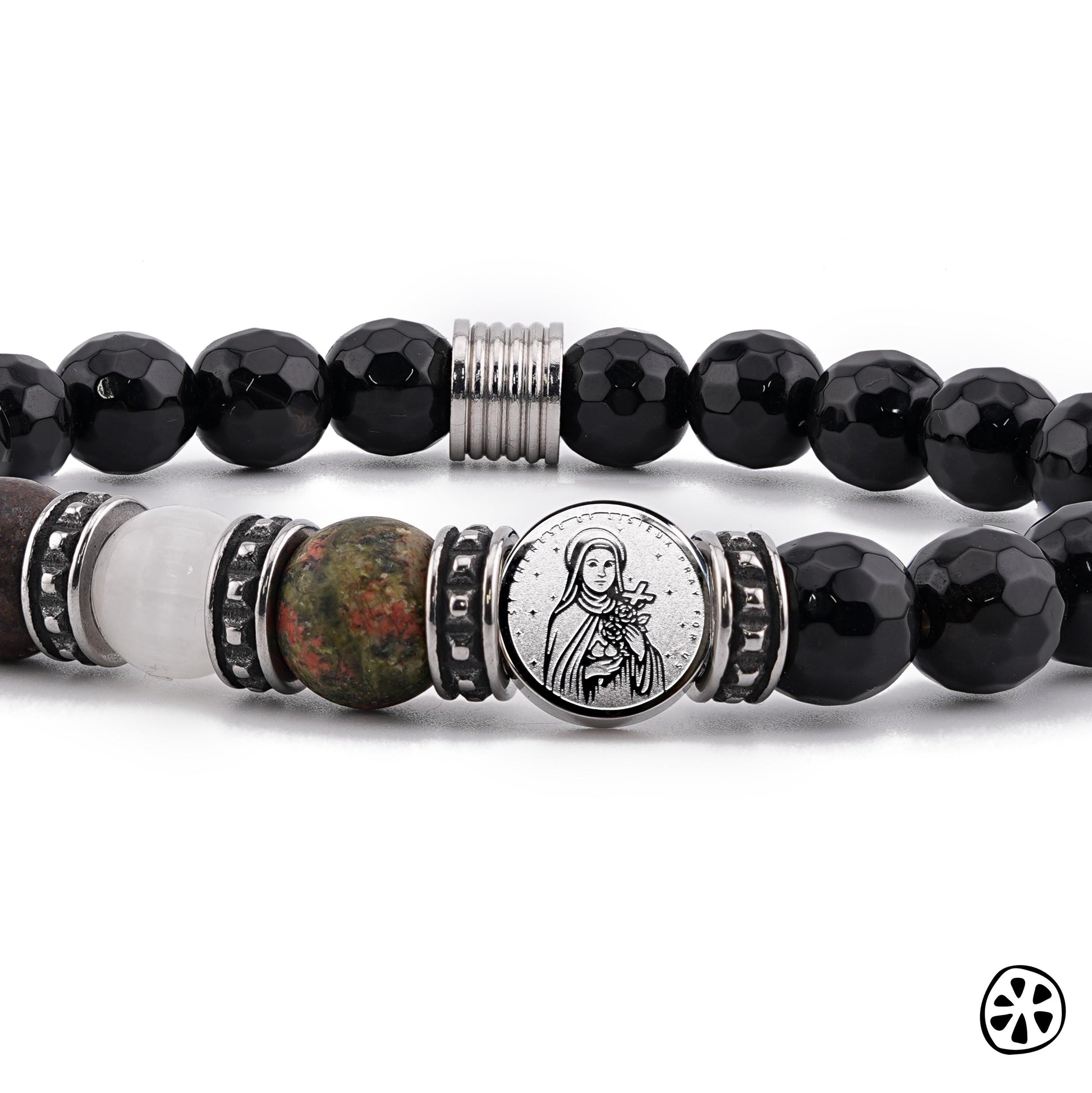 Close-up view of a St. Thérèse of Lisieux protection bracelet featuring a dual-sided stainless steel saint charm centered between faceted 8mm black onyx beads and natural gemstones, including bronzite, selenite, and unakite. Tarnish-free stainless steel accents add durability and shine. Displayed on a clean white background, this handmade Catholic bracelet highlights its premium materials, devotional meaning, and polished craftsmanship.